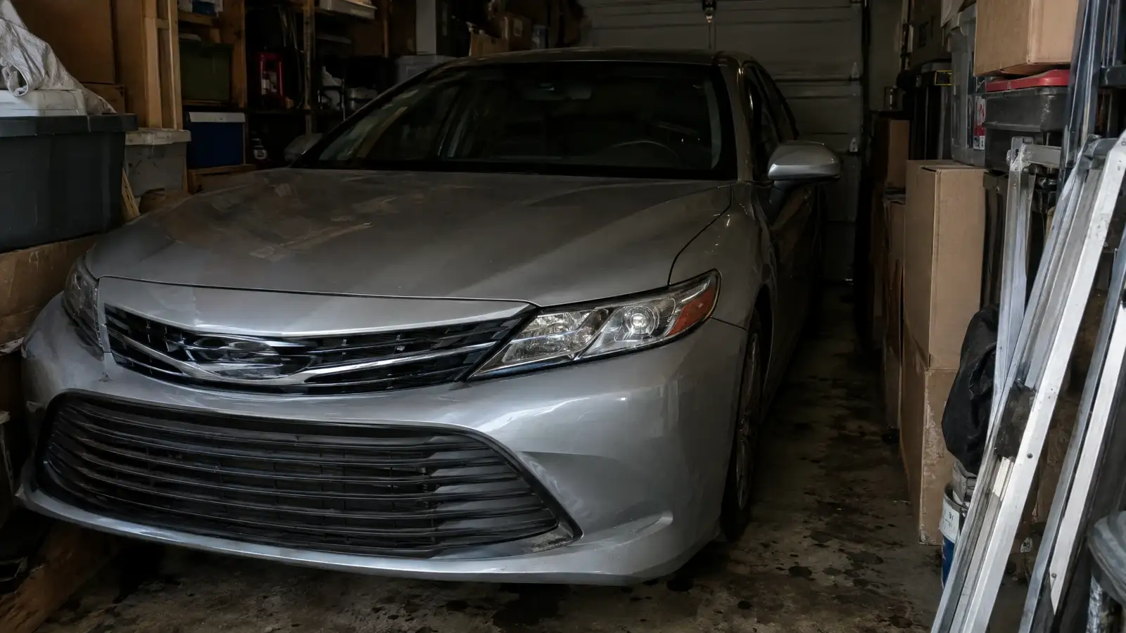 Before: a sedan squeezed into a cluttered garage with boxes stacked around it